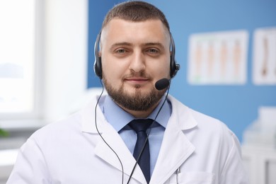 Photo of Doctor with headset in clinic. Online medical consultation