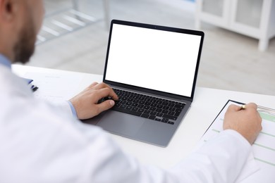 Photo of Doctor using laptop in clinic, closeup. Online medical consultation