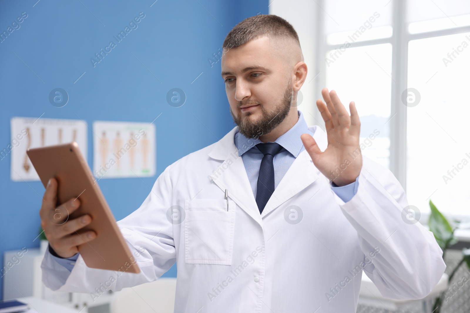 Doctor with tablet having online consultation in clinic Photo of Doctor with tablet having online consultation in clinic