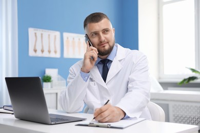 Photo of Doctor having online consultation via smartphone in clinic