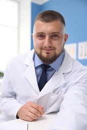 Photo of Doctor having online consultation at table in clinic