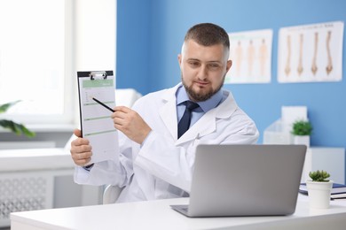 Photo of Doctor having online consultation via laptop in clinic