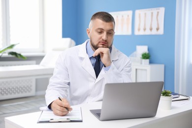 Photo of Doctor having online consultation via laptop in clinic