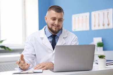 Photo of Doctor having online consultation via laptop in clinic