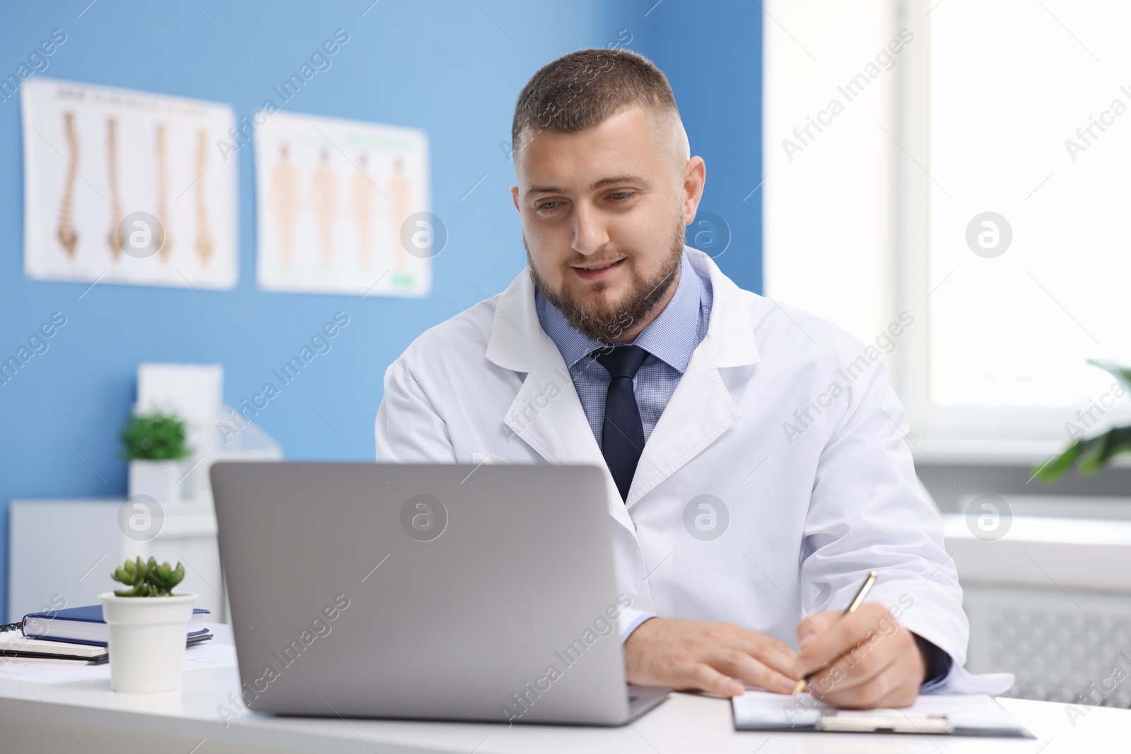 Doctor having online consultation via laptop in clinic Photo of Doctor having online consultation via laptop in clinic