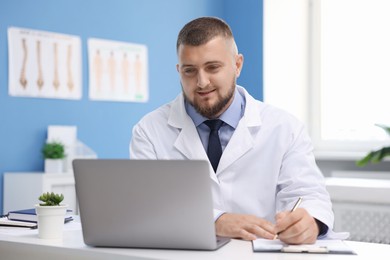 Photo of Doctor having online consultation via laptop in clinic