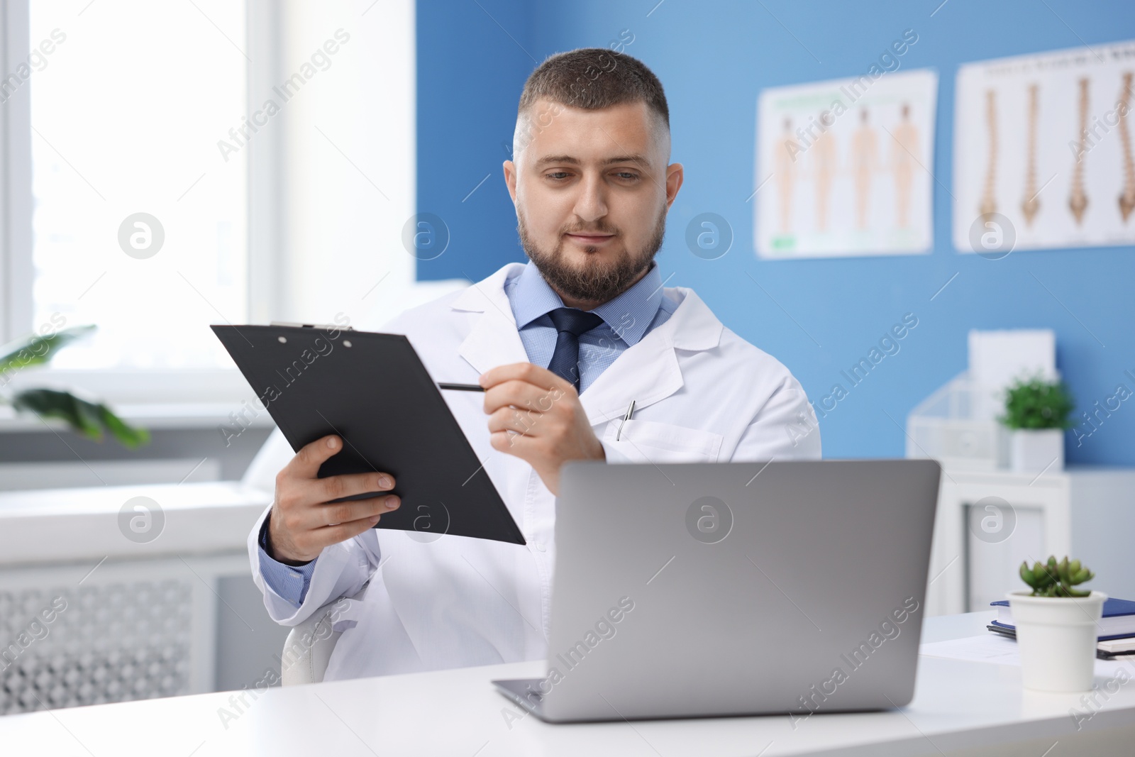 Doctor having online consultation via laptop in clinic Photo of Doctor having online consultation via laptop in clinic
