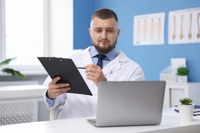 Photo of Doctor having online consultation via laptop in clinic
