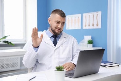 Photo of Doctor having online consultation via laptop in clinic