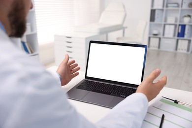 Photo of Doctor having online consultation via laptop in clinic, closeup