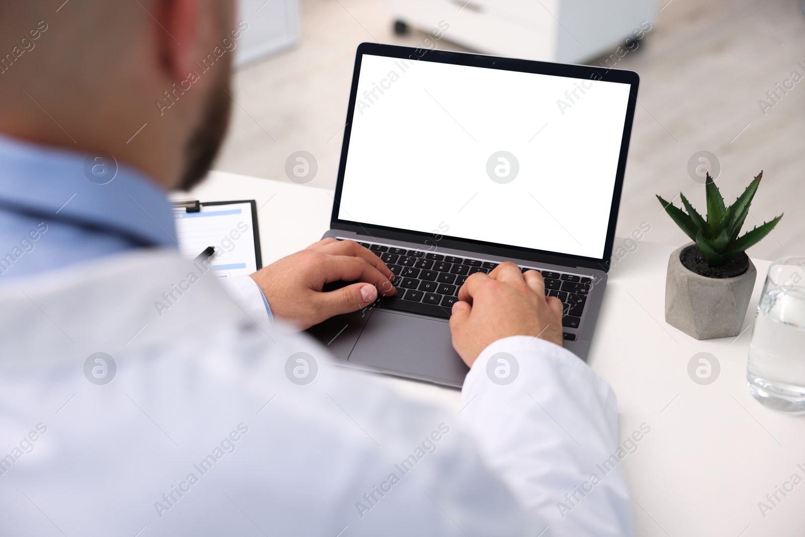 Doctor having online consultation via laptop in clinic, closeup Photo of Doctor having online consultation via laptop in clinic, closeup