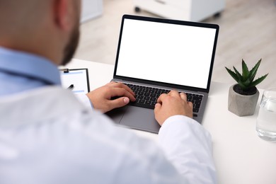 Photo of Doctor having online consultation via laptop in clinic, closeup