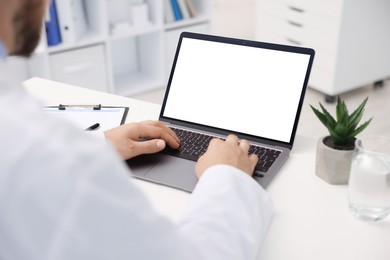 Photo of Doctor having online consultation via laptop in clinic, closeup