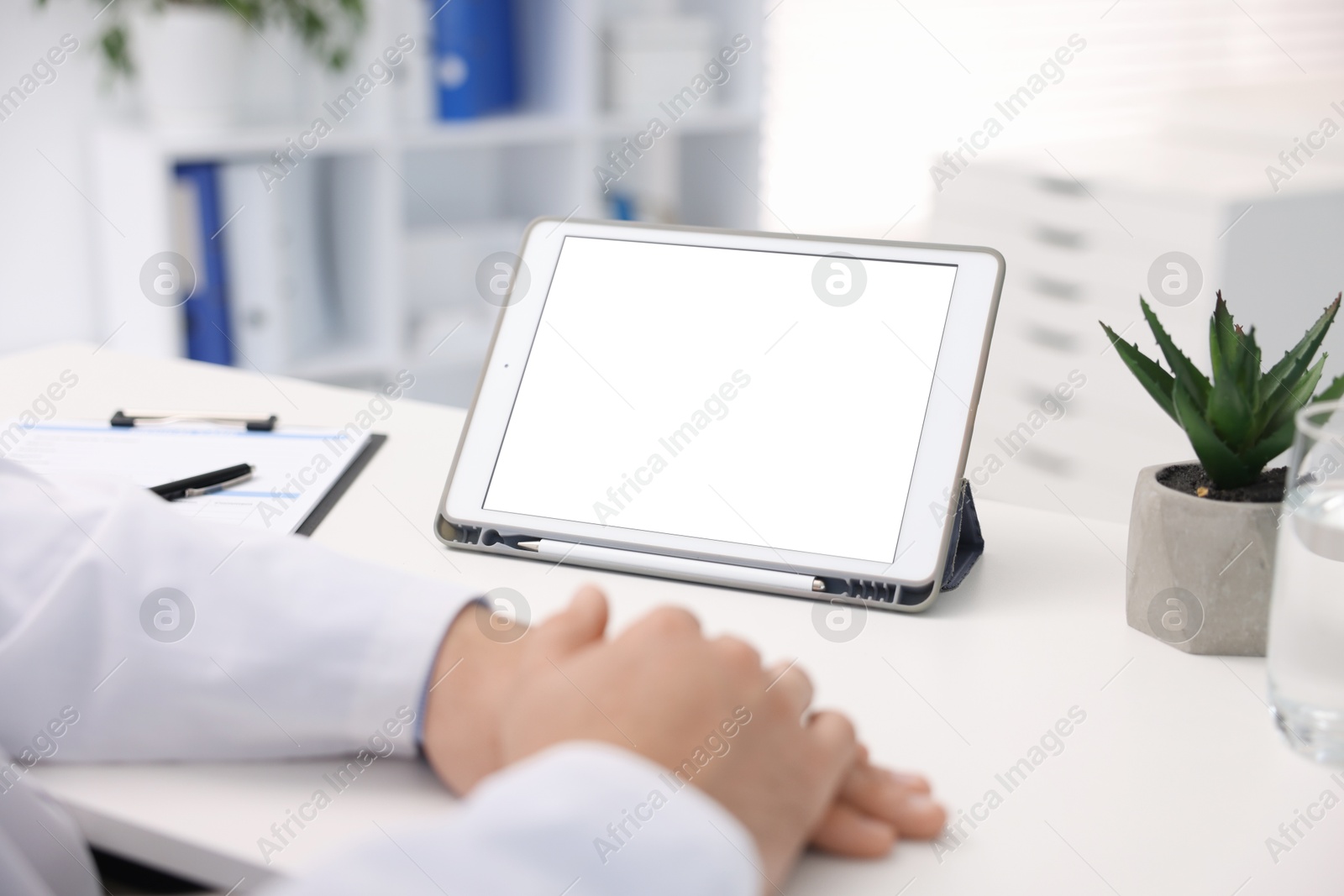 Doctor having online consultation via tablet in clinic, closeup Photo of Doctor having online consultation via tablet in clinic, closeup