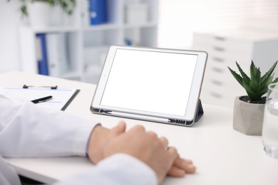 Photo of Doctor having online consultation via tablet in clinic, closeup