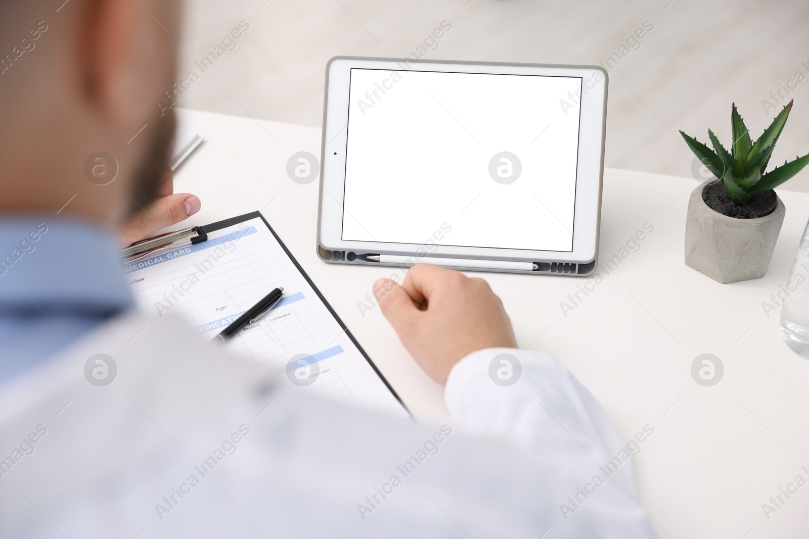 Doctor having online consultation via tablet in clinic, closeup Photo of Doctor having online consultation via tablet in clinic, closeup