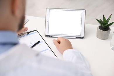 Photo of Doctor having online consultation via tablet in clinic, closeup