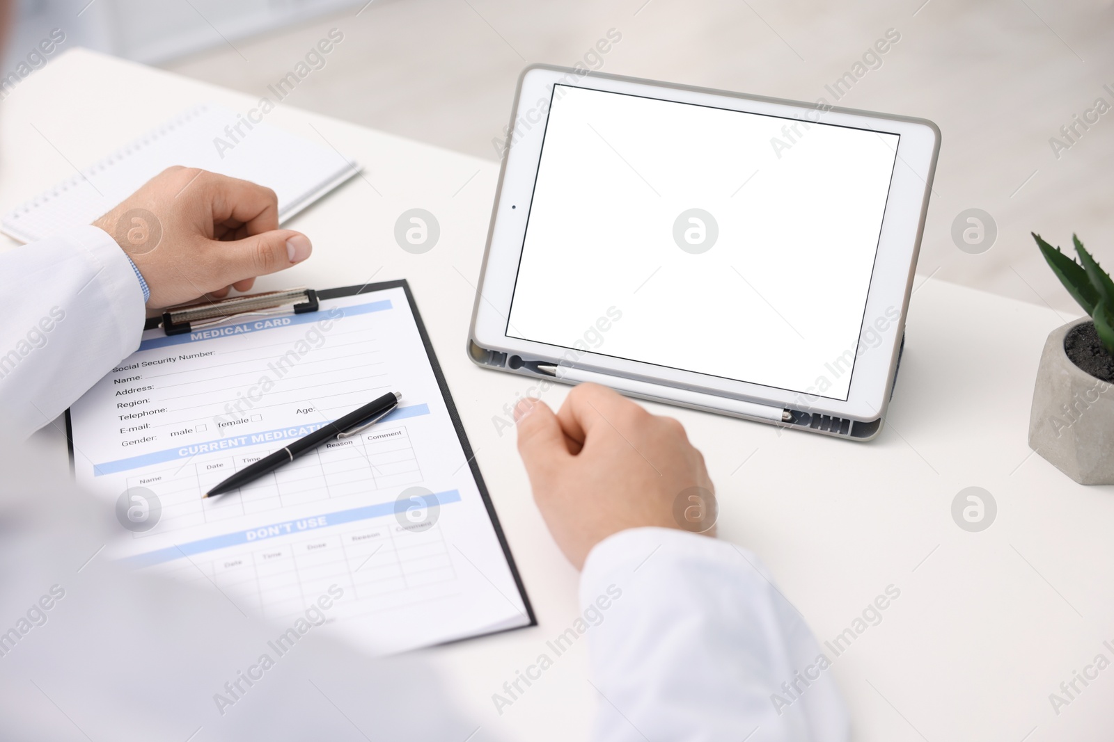 Doctor having online consultation via tablet in clinic, closeup Photo of Doctor having online consultation via tablet in clinic, closeup