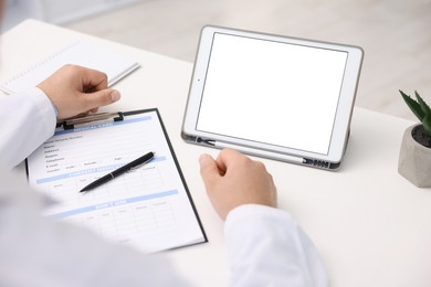 Photo of Doctor having online consultation via tablet in clinic, closeup
