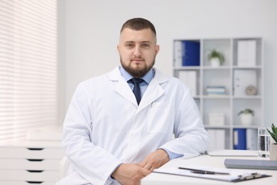 Photo of Portrait of doctor in uniform at table indoors