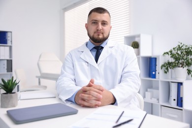 Photo of Portrait of doctor in uniform at table indoors