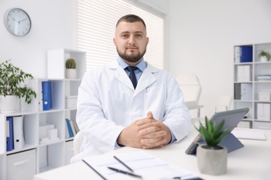 Photo of Portrait of doctor in uniform at table indoors