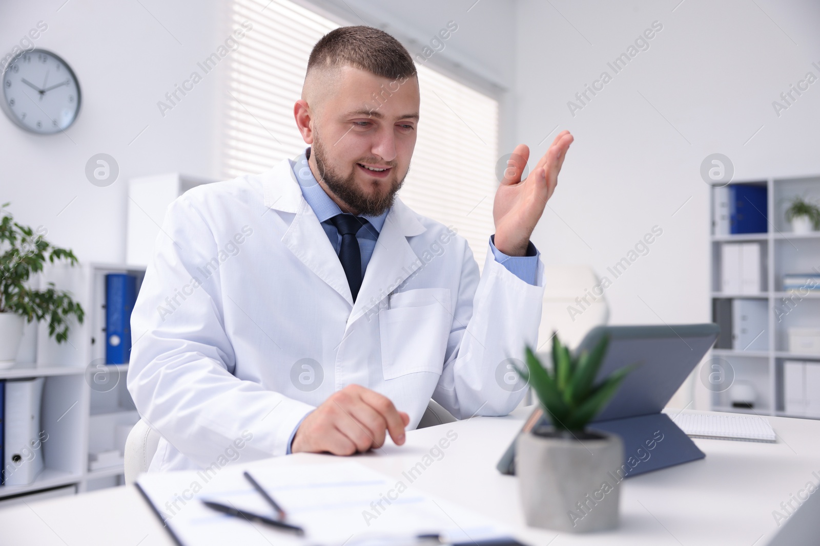 Doctor having online consultation via tablet indoors Photo of Doctor having online consultation via tablet indoors