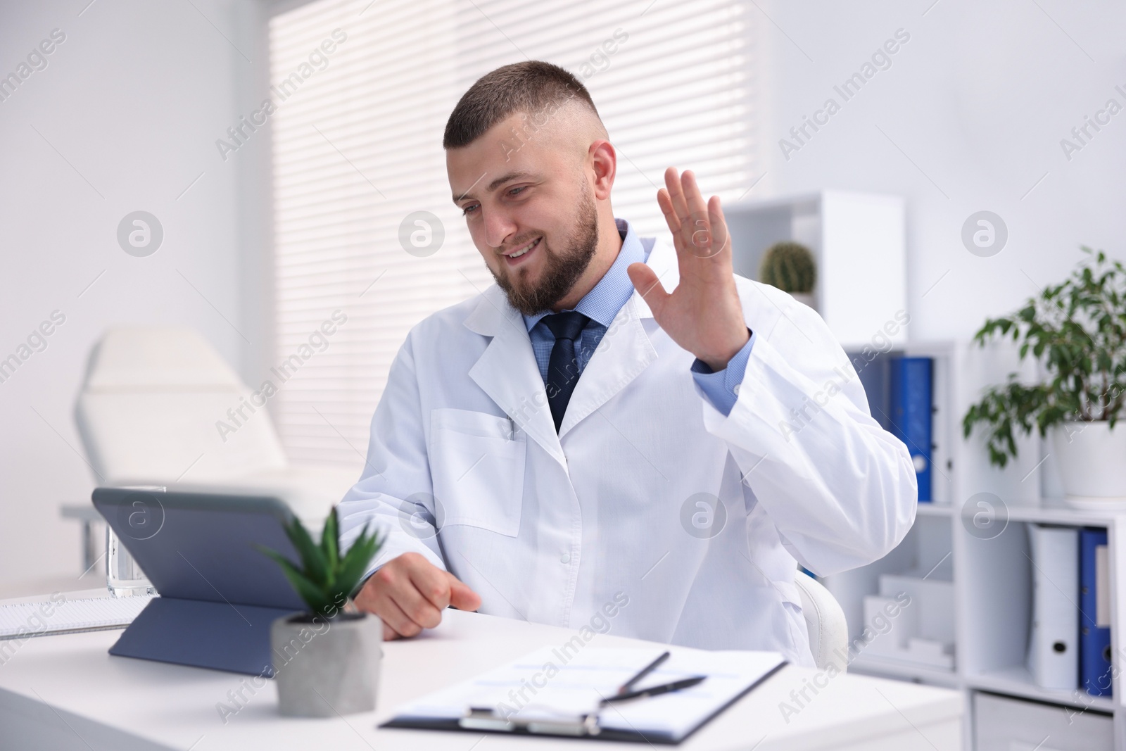 Doctor having online consultation via tablet indoors Photo of Doctor having online consultation via tablet indoors