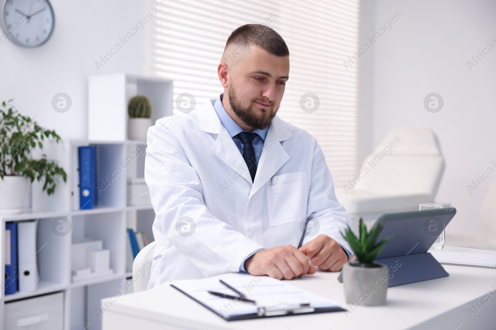 Doctor having online consultation via tablet indoors Photo of Doctor having online consultation via tablet indoors