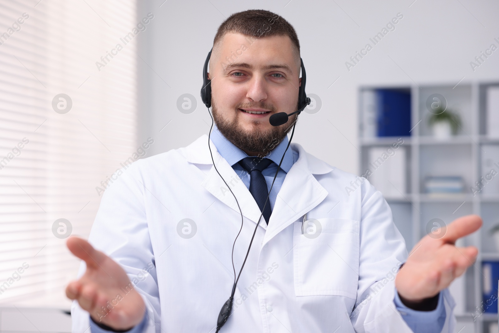 Doctor with headset having online consultation in clinic Photo of Doctor with headset having online consultation in clinic