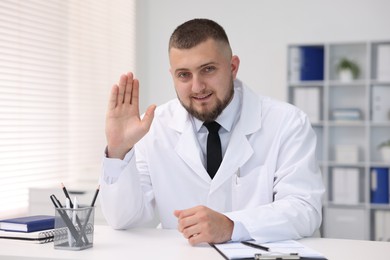 Photo of Portrait of doctor in uniform at table indoors