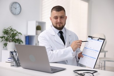 Photo of Doctor having online consultation via laptop in clinic