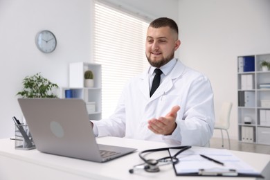 Photo of Doctor having online consultation via laptop in clinic