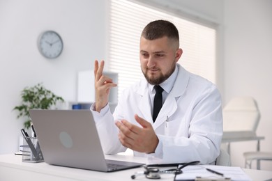 Photo of Doctor having online consultation via laptop in clinic