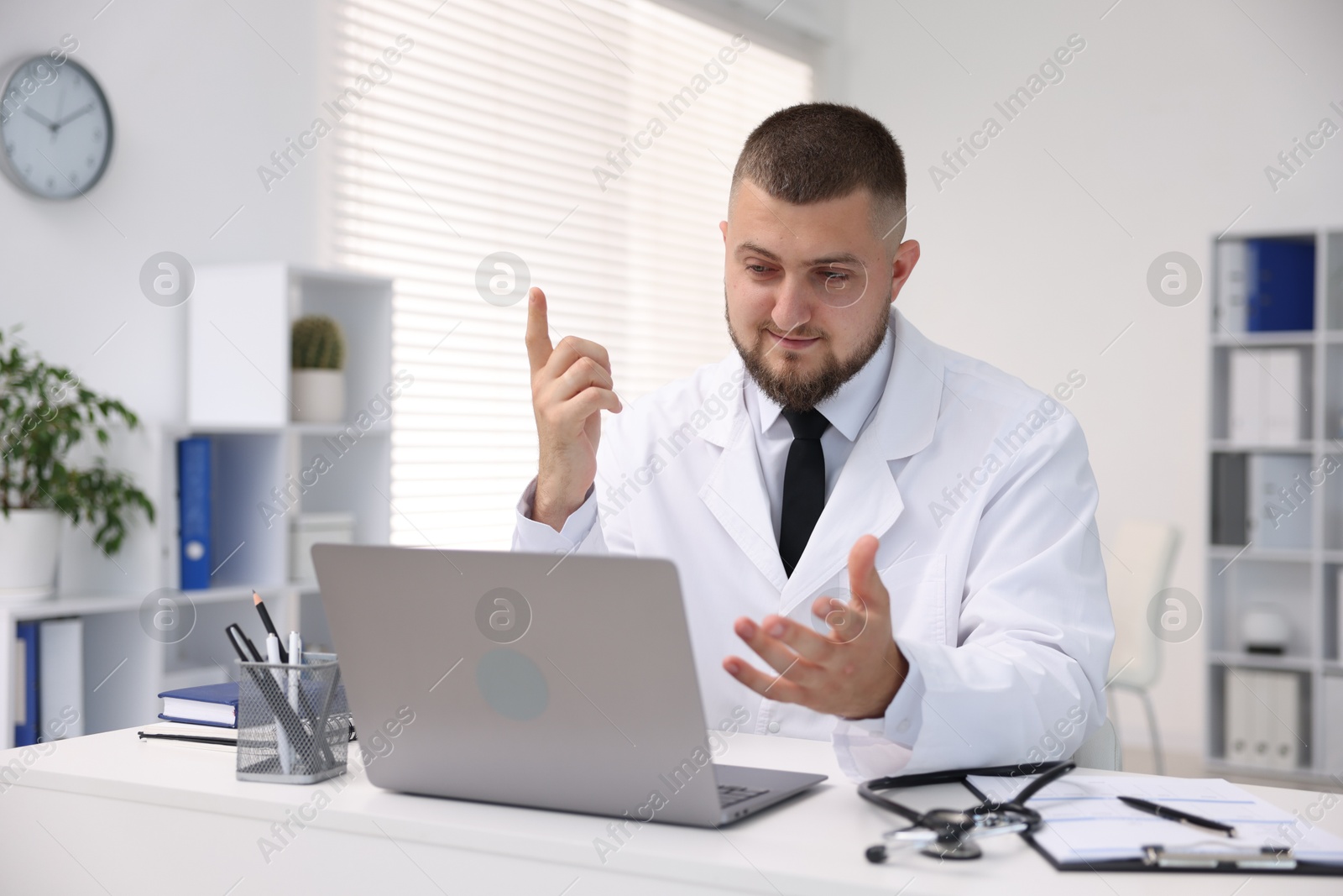 Doctor having online consultation via laptop in clinic Photo of Doctor having online consultation via laptop in clinic