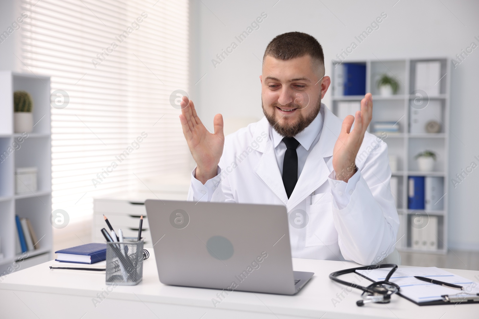 Doctor having online consultation via laptop in clinic Photo of Doctor having online consultation via laptop in clinic