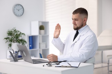 Photo of Doctor having online consultation via laptop in clinic