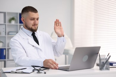 Photo of Doctor having online consultation via laptop in clinic