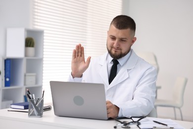 Photo of Doctor having online consultation via laptop in clinic
