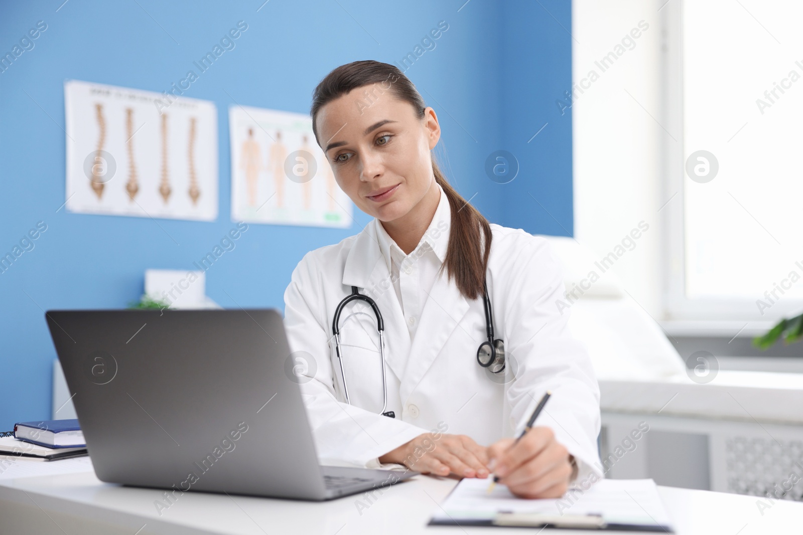 Photo of Doctor having online consultation via laptop in clinic