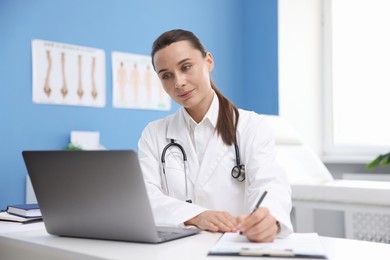 Photo of Doctor having online consultation via laptop in clinic
