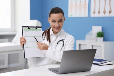 Photo of Doctor having online consultation via laptop in clinic