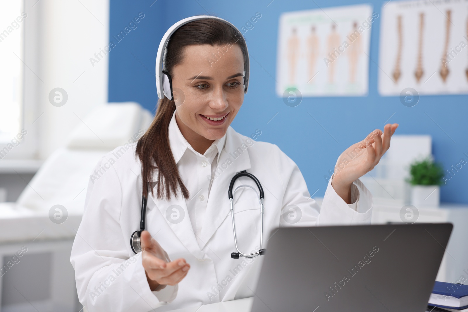 Doctor in headphones having online consultation via laptop indoors Photo of Doctor in headphones having online consultation via laptop indoors