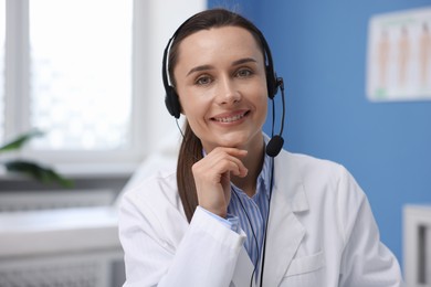 Photo of Doctor with headset having online consultation in clinic