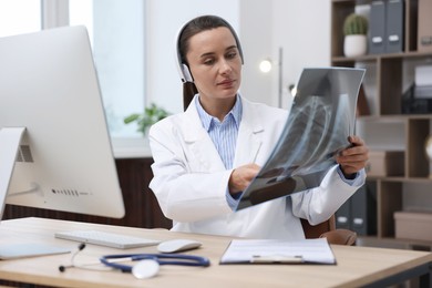 Photo of Doctor with lung MRI scan having online consultation via computer in clinic
