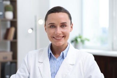 Photo of Portrait of happy doctor in uniform indoors
