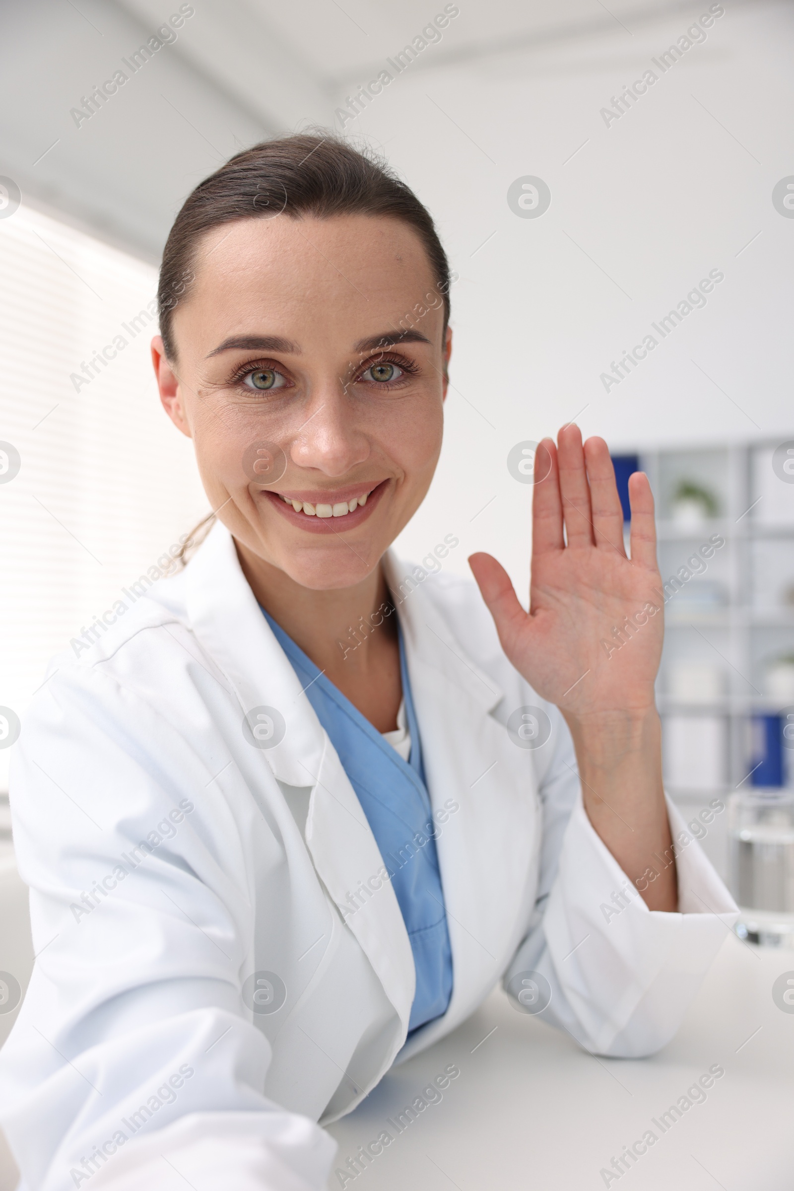Doctor having online consultation at table in clinic Photo of Doctor having online consultation at table in clinic