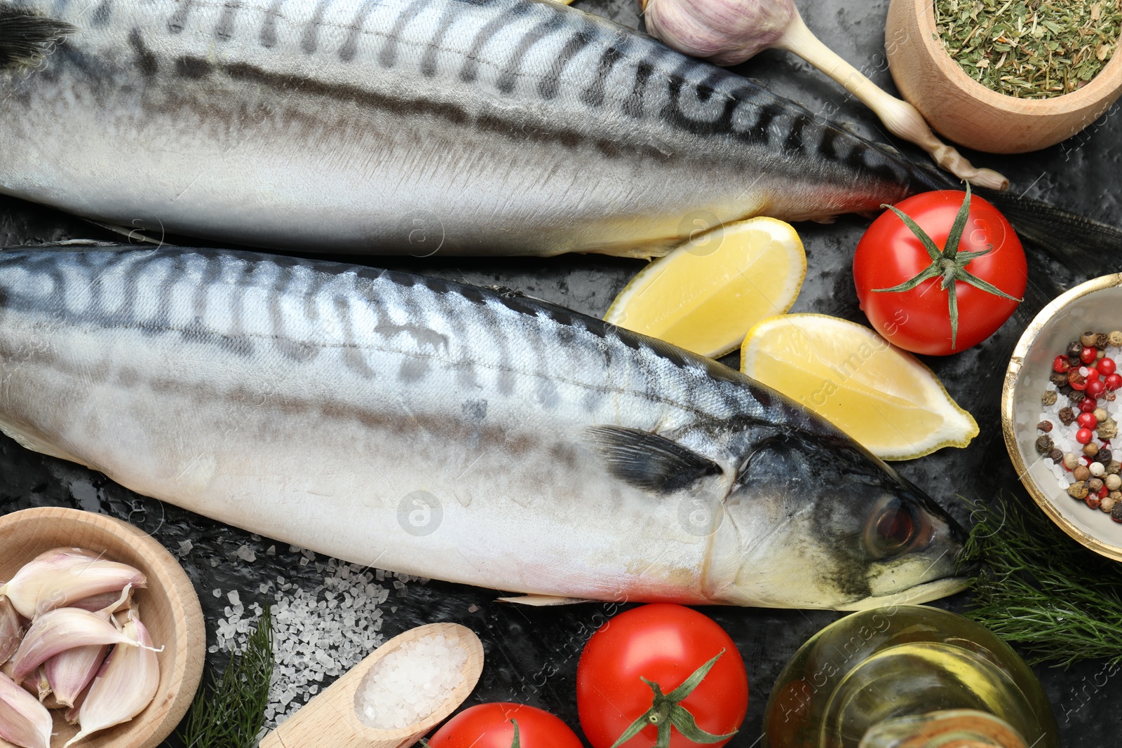 Fresh raw mackerels and spices on black table, flat lay. Seafood delicacies Photo of Fresh raw mackerels and spices on black table, flat lay. Seafood delicacies