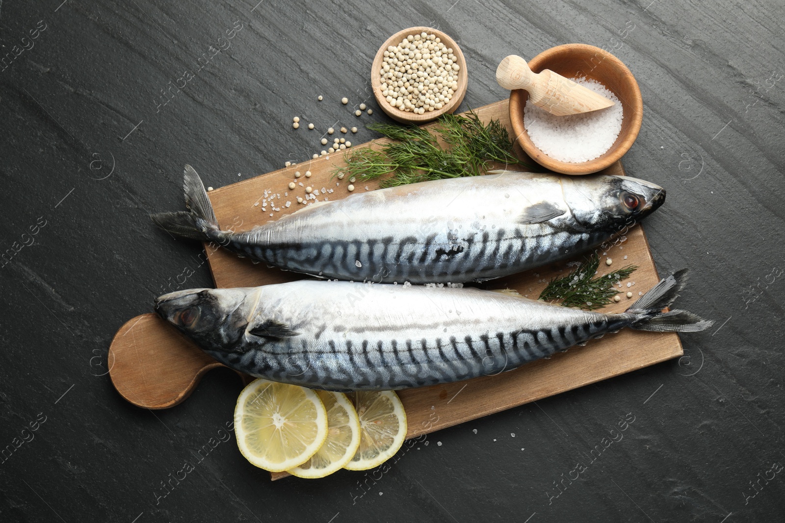 Fresh raw mackerels and spices on black table, flat lay. Seafood delicacies Photo of Fresh raw mackerels and spices on black table, flat lay. Seafood delicacies
