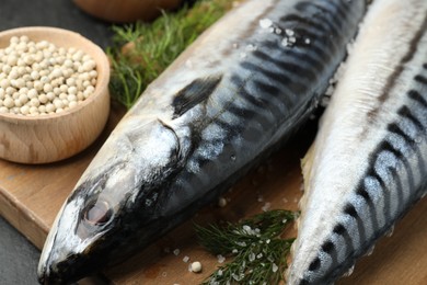 Photo of Fresh raw mackerels and spices on table, closeup. Seafood delicacies